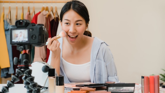 Beauty blogger present beauty cosmetics sitting in front camera for recording video. 