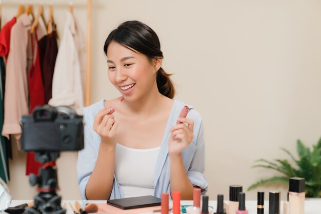 Free Photo beauty blogger present beauty cosmetics sitting in front camera for recording video. 