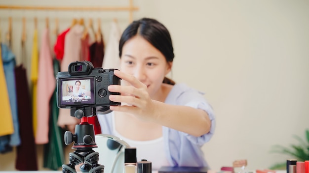 Beauty blogger present beauty cosmetics sitting in front camera for recording video. 