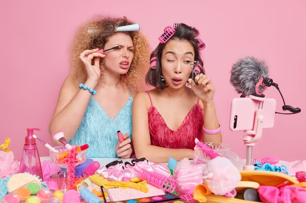 Beauty blogging concept. Two women do makeup record video apply mascara