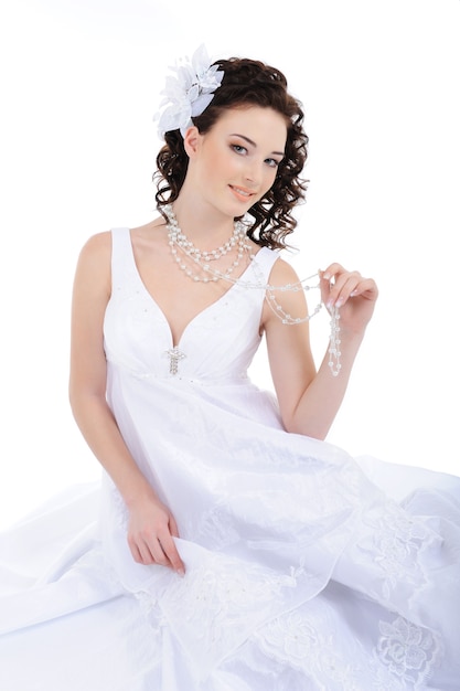 巻き毛を持つ白いウェディングドレスの美しさの花嫁