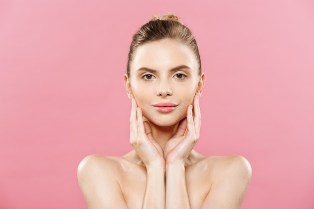 Beauty Concept - Beautiful Caucasian woman with clean skin, natural make-up isolated on bright pink background with copy space.