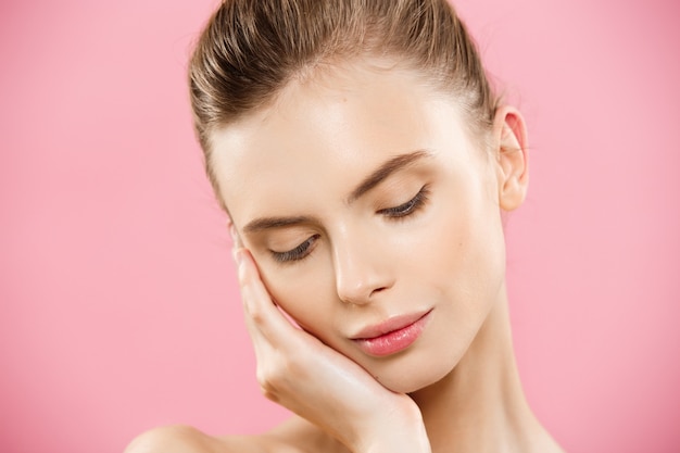 Beauty Concept - Beautiful Caucasian woman with clean skin, natural make-up isolated on bright pink background with copy space.