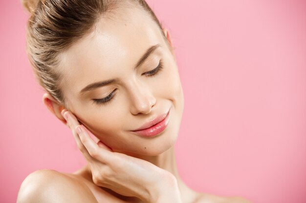 Beauty Concept - Beautiful Caucasian woman with clean skin, natural make-up isolated on bright pink background with copy space.