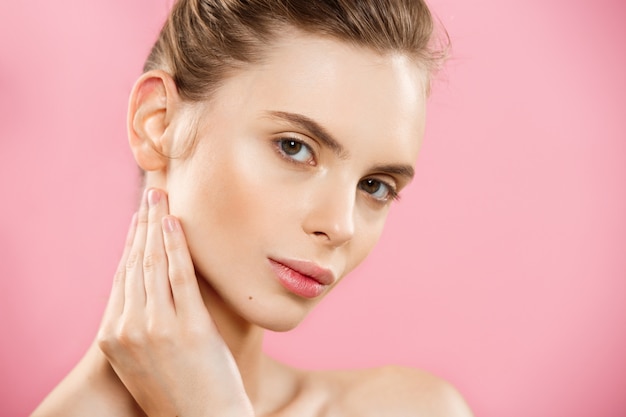 Beauty Concept - Beautiful Caucasian woman with clean skin, natural make-up isolated on bright pink background with copy space.