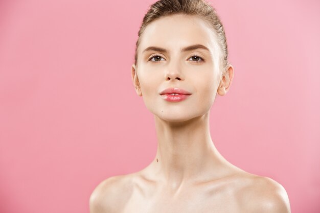 Beauty Concept - Beautiful Caucasian woman with clean skin, natural make-up isolated on bright pink background with copy space.