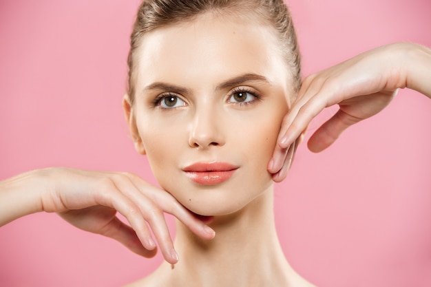 Free photo beauty concept - beautiful caucasian woman with clean skin, natural make-up isolated on bright pink background with copy space.