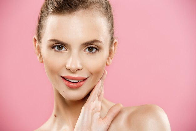 Beauty Concept - Beautiful Caucasian woman with clean skin, natural make-up isolated on bright pink background with copy space.