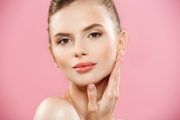 Beauty Concept - Beautiful Caucasian woman with clean skin, natural make-up isolated on bright pink background with copy space.