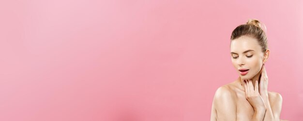 밝은 분홍색 배경에 격리된 깨끗한 피부 천연 화장을 한 아름다움 개념 아름다운 백인 여성