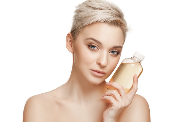 Beauty concept. caucasian pretty woman with perfect skin holding oil bottle