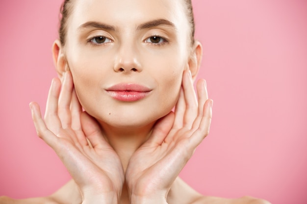 Beauty Concept - Close up Portrait of attractive caucasian girl with beauty natural skin isolated on pink background with copy space. 