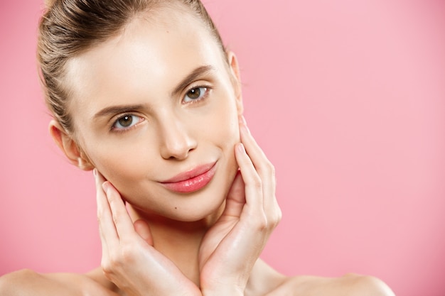 Beauty Concept - Close up Portrait of attractive caucasian girl with beauty natural skin isolated on pink background with copy space. 