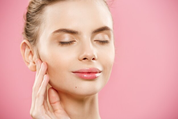 Beauty Concept - Close up Portrait of attractive caucasian girl with beauty natural skin isolated on pink background with copy space. 