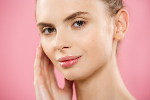 Beauty Concept - Close up Portrait of attractive caucasian girl with beauty natural skin isolated on pink background with copy space. 