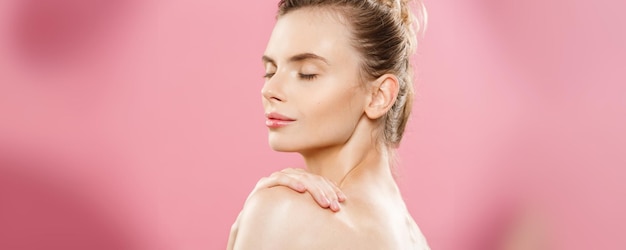 Beauty Concept Close up Portrait of attractive caucasian girl with beauty natural skin isolated on pink background with copy space