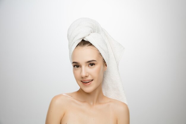 Beauty Day. Woman wearing towel isolated on white studio background. Day for self-care, skin-care, beauty routine.