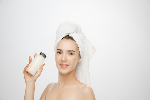 Beauty Day. Woman wearing towel isolated on white studio background. Day for self-care, skin-care, beauty routine.