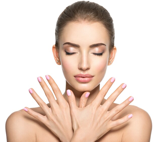 Beauty face of the young beautiful woman - isolated on white. Female with nice fingernail. Pretty young girl shows hands before face with a pink nails