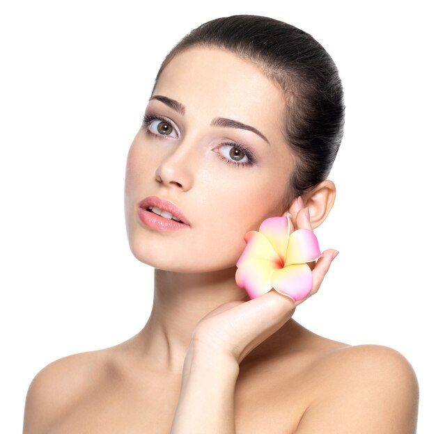 Beauty face of young woman with flower. Beauty treatment concept.