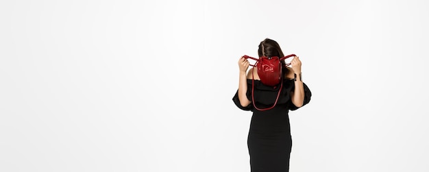Free photo beauty and fashion concept full length of young woman sticking head inside purse and searching somet