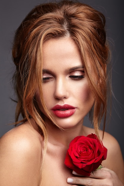 Beauty fashion portrait of young blond woman model with natural makeup and perfect skin with beautiful rose  posing