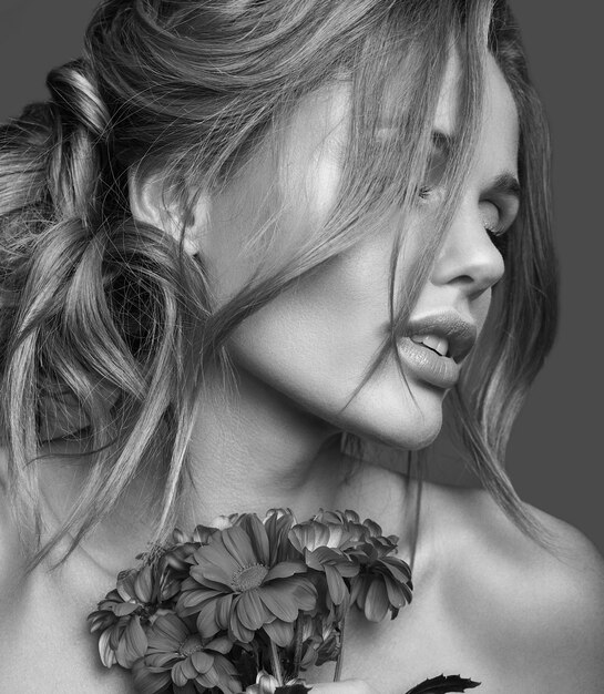 Портрет моды красоты молодой белокурой модели женщины с естественным составом и совершенной кожи с ярким представлять цветков