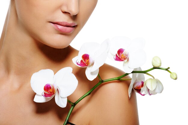 Beauty flower lying on nude  female shoulder with  clean healthy skin