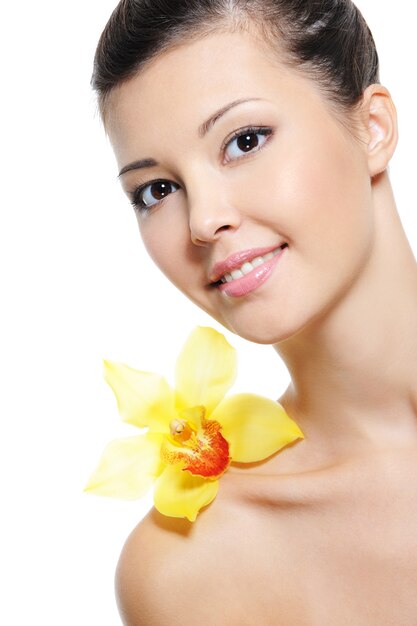 Beauty happy young asian girl with yllow orchid on her shoulder