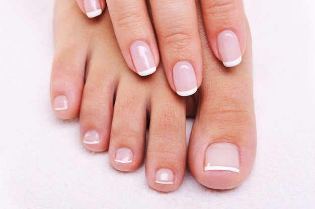 Free photo beauty nails concept of a female hand and feet with beautiful french manicure and pedicure