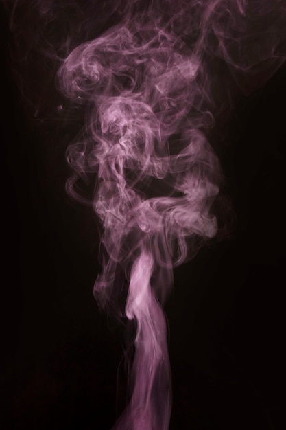 Foto gratuita fumo rosa di bellezza che si muove verso l'alto su fondo nero