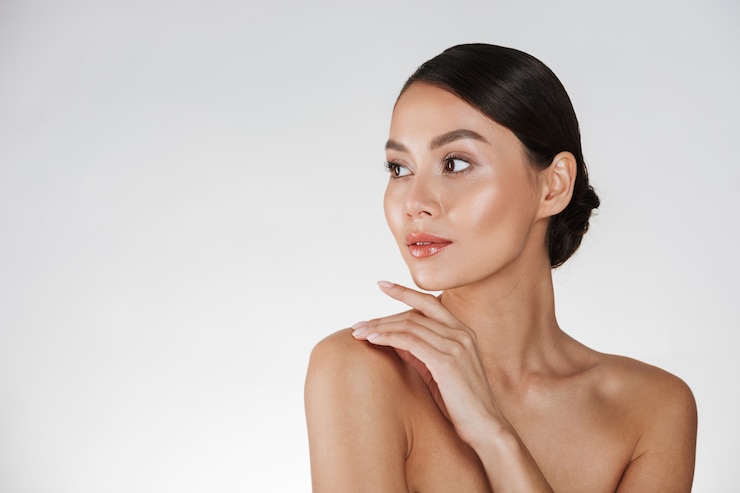 Free Photo beauty portrait of feminine young woman looking away and touching her nude shoulder, isolated over white
