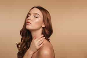 Free photo beauty portrait of ginger woman with long hair posing sideways with closed eyes