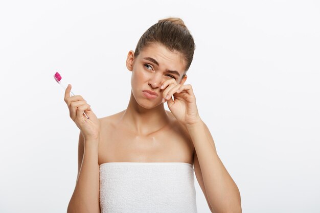 Free photo beauty portrait of a happy beautiful half naked woman brushing her teeth with a toothbrush and looki