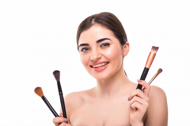 Beauty portrait of a happy beautiful half naked woman holding set of make-up brushes