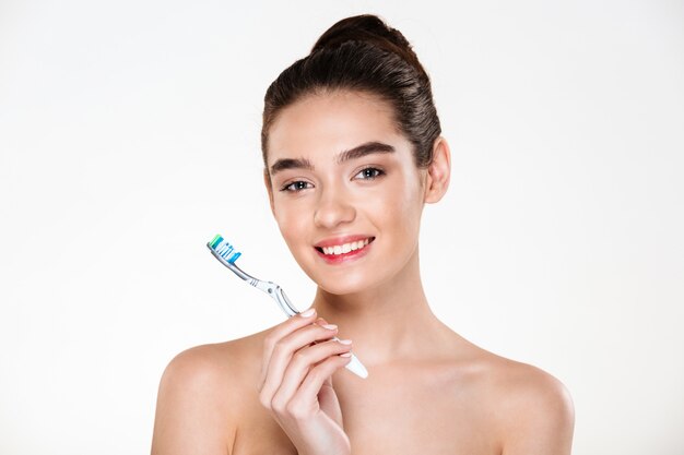 Beauty portrait of healthy beautiful half-naked woman brushing her teeth with toothbrush having oral hygiene