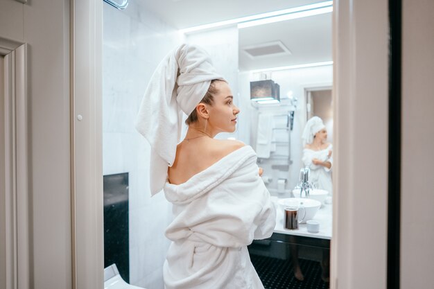 Beauty portrait of pretty woman dressing a white bath towel