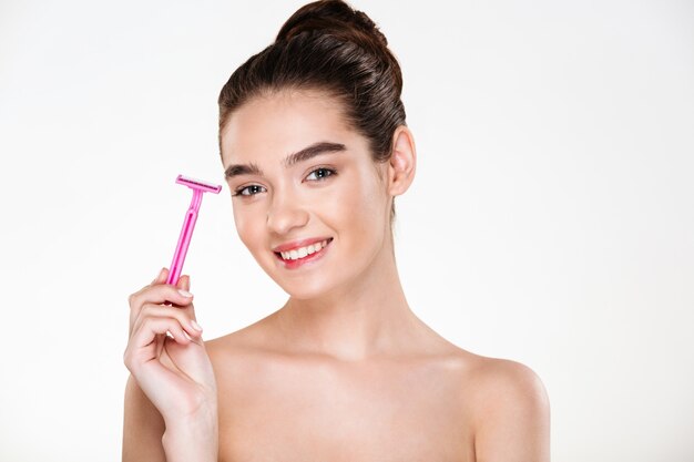 Beauty portrait of pretty woman with soft skin holding razor and looking with smile