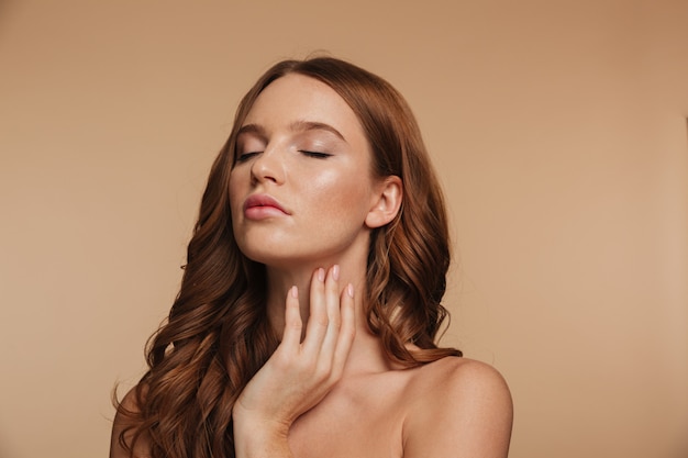 Beauty portrait of sensual ginger woman with long hair posing with closed eyes