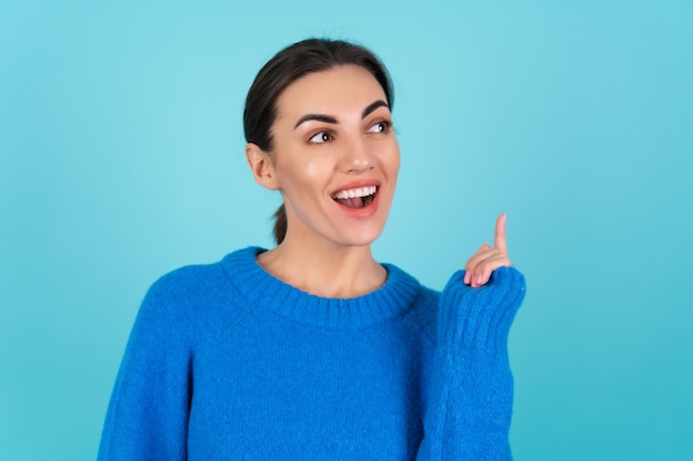 Beauty portrait of a young woman in a blue knitted sweater and natural daytime makeup, inspired by a sudden idea