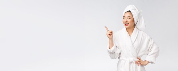 Beauty portrait of young woman showing and pointing finger to empty copy space asian beauty in bathrobe