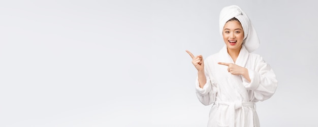 Beauty portrait of young woman showing and pointing finger to empty copy space asian beauty in bathrobe