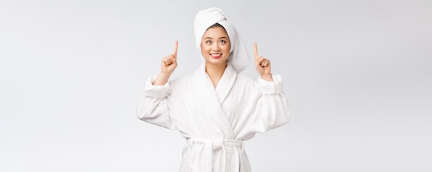 Beauty portrait of young woman showing and pointing finger to empty copy space asian beauty in bathrobe