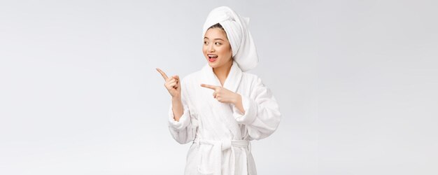 Beauty portrait of young woman showing and pointing finger to empty copy space asian beauty in bathrobe