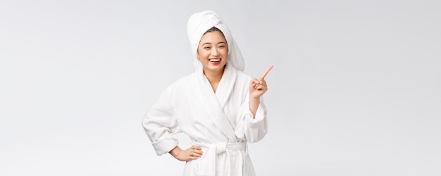 Beauty portrait of young woman showing and pointing finger to empty copy space asian beauty in bathrobe