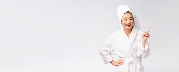 Beauty portrait of young woman showing and pointing finger to empty copy space asian beauty in bathrobe