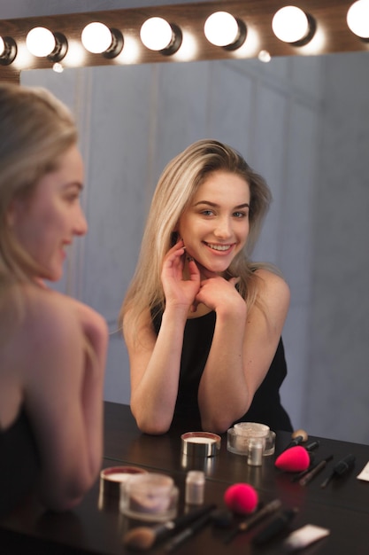 Free photo beauty woman applying makeup