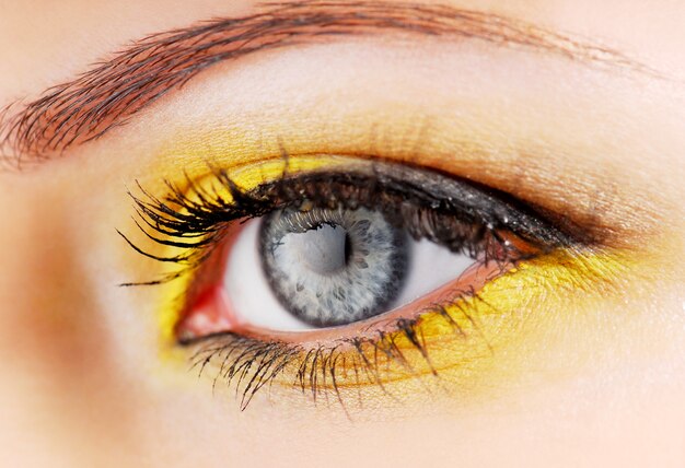 Красота. Глаз женщины с желтыми тенями для век.