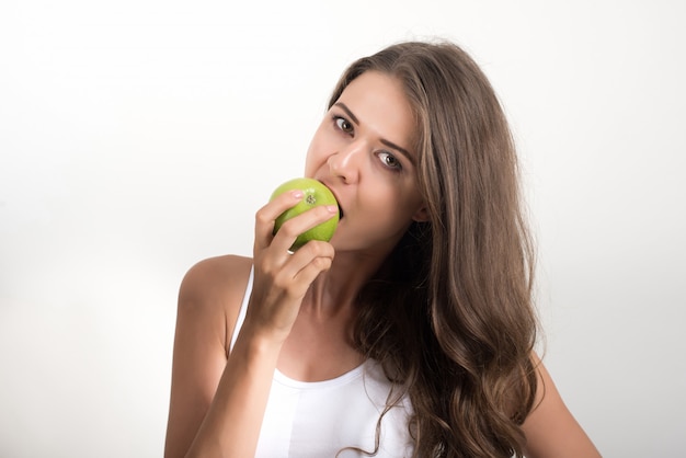 Beauty woman holding green apple while isolated on white