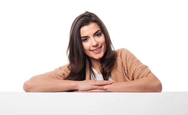 Beauty woman leaning on white empty board